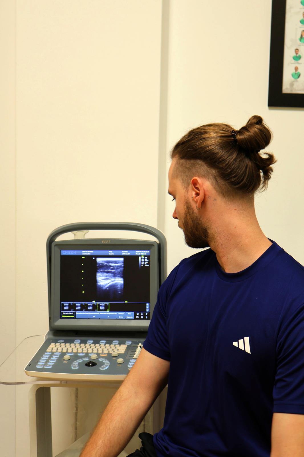 Aarón Olaso utilizando ecografía en fisioterapia para valorar una lesión muscular en Gandia y La Safor